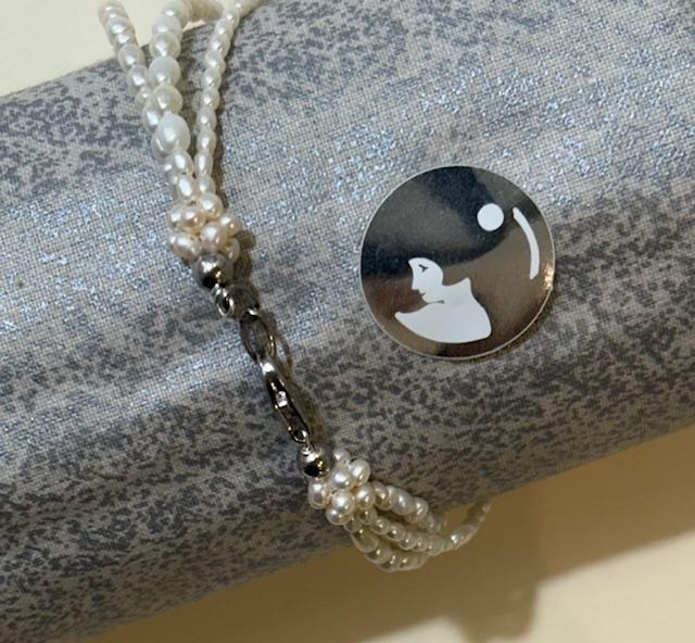 BRACELET 3 RANGS PERLES EAU DOUCE GRAINS DE RIZ FINITION COQUILLE RESILLE FERMOIR ARGENT.